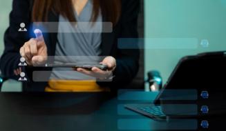 Mulher interage com uma interface digital holográfica via tablet, representando tecnologia de gestão de contatos ou atendimento ao cliente.