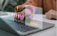 Mãos sobre notebook com projeção holográfica de organograma e infográficos, representando gestão de pessoas e estrutura organizacional.