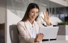 Mulher de negócios ou professora sorridente usando tablet em ambiente de escritório, com expressão de felicidade e água na mão, em um cenário moderno e profissional